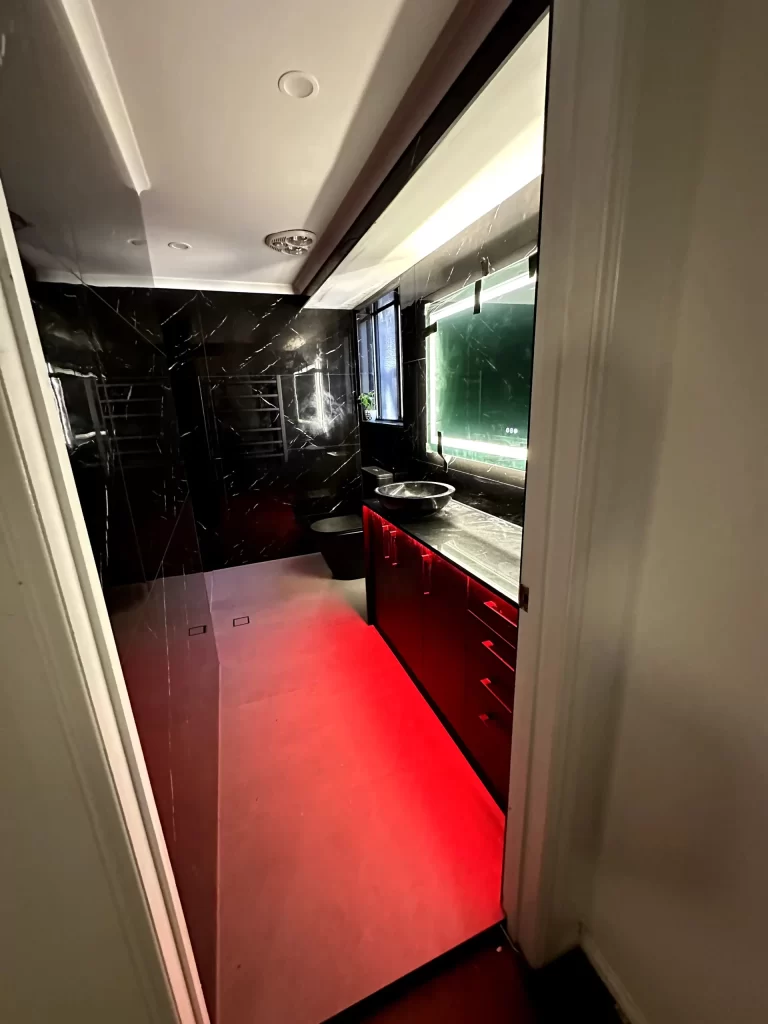 Colour LED strip lighting under a bathroom vanity, with a strip light in the bulkhead above the mirror, Brisbane