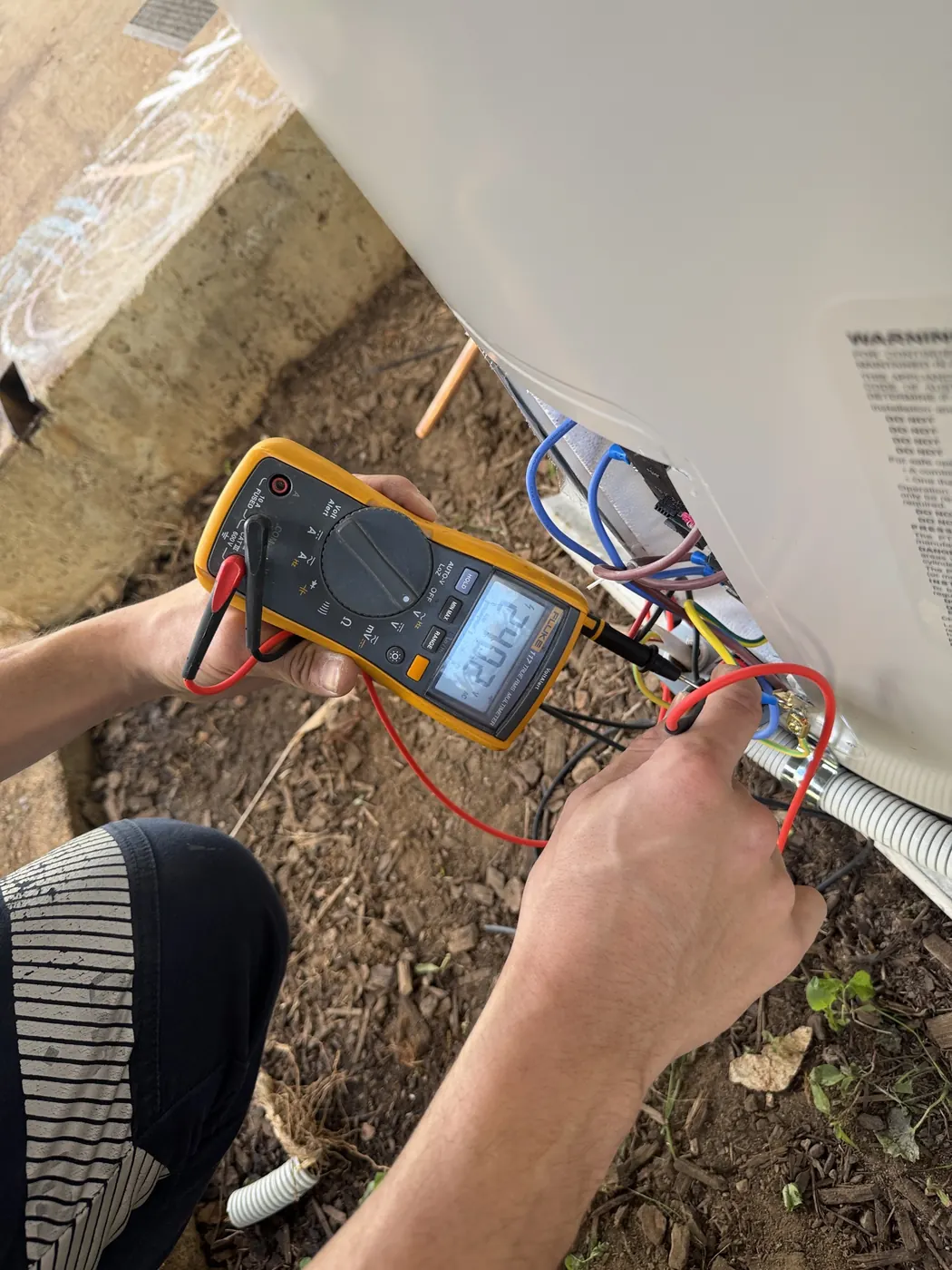 Electrical fault finding in Brisbane: an M-Tech electrician testing a circuit with a multimeter
