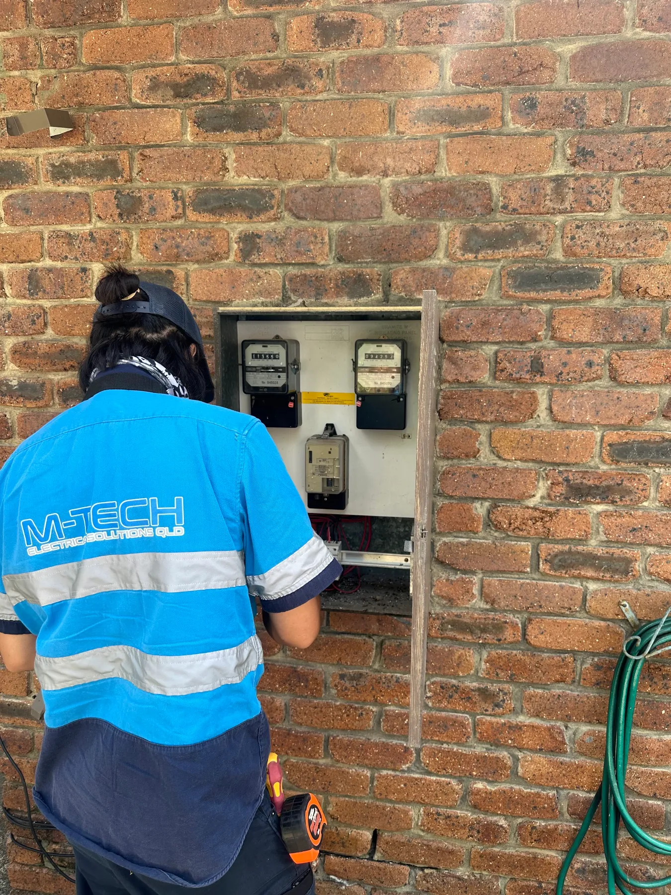 M-Tech electrician testing a meter box during electrical fault finding on a Brisbane home