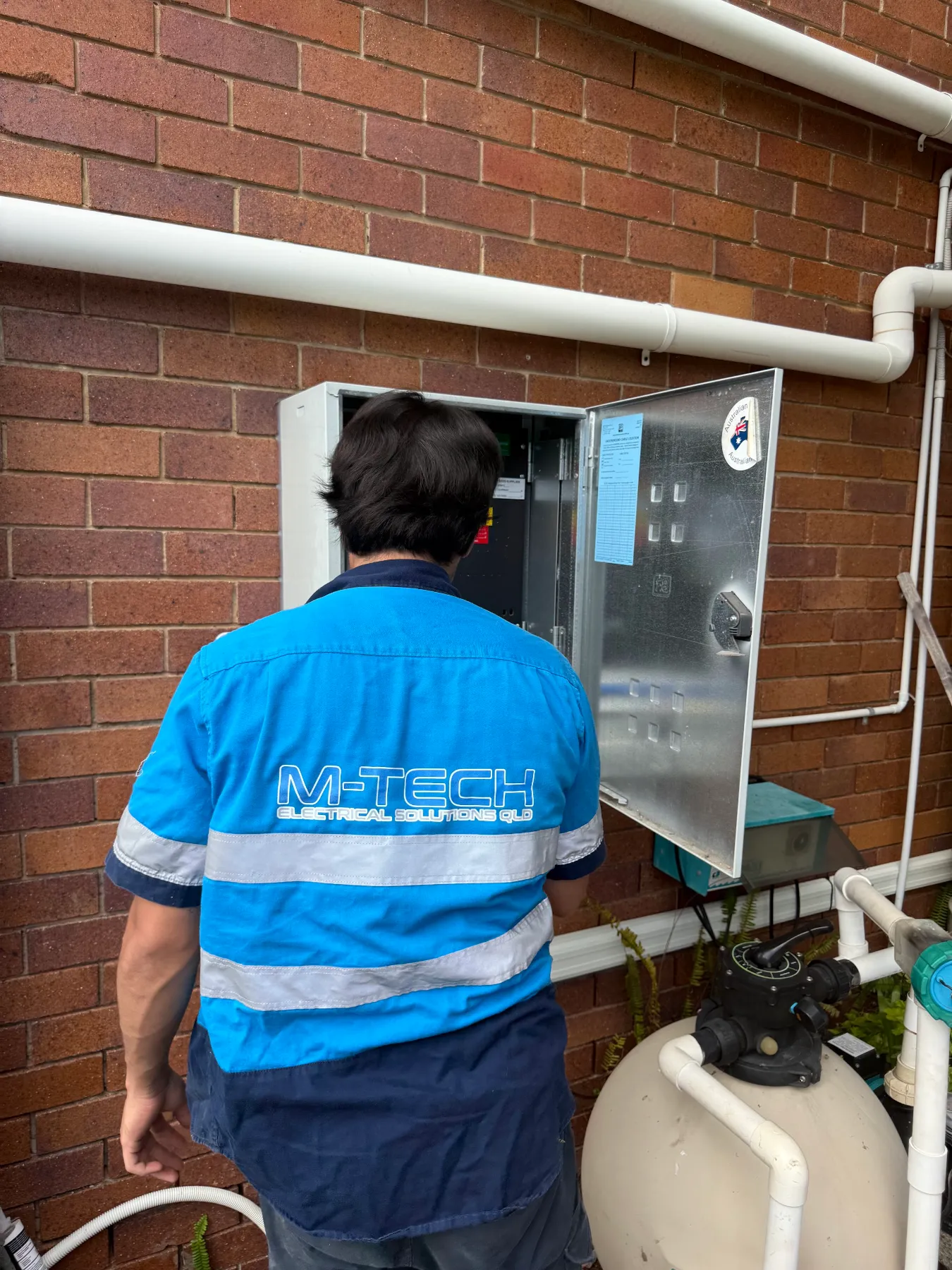 M-Tech emergency electrician testing a switchboard at a Brisbane home