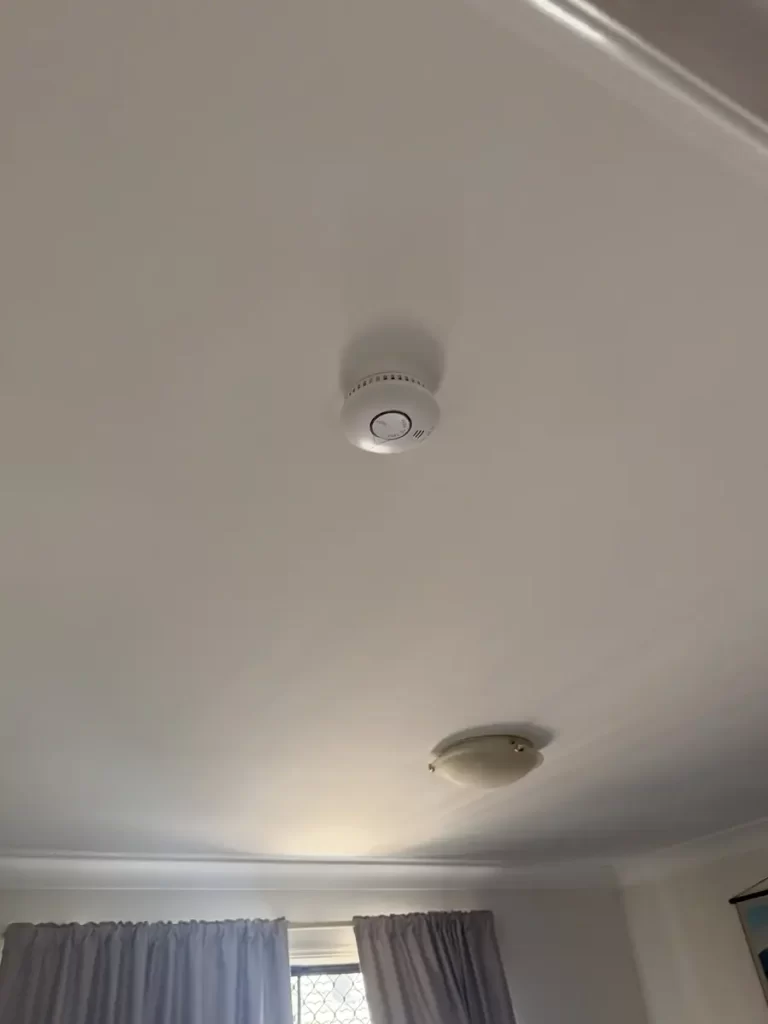 Interconnected photoelectric smoke alarm on a living area ceiling in a Carindale home