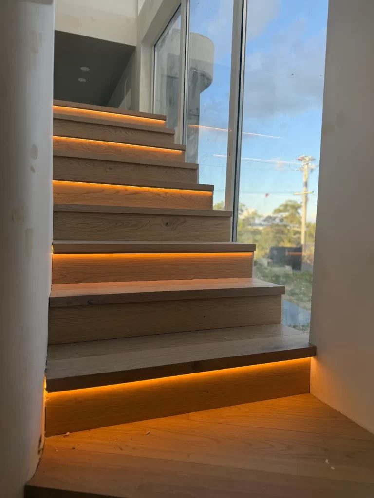 Timber staircase with warm LED strip lighting under each tread