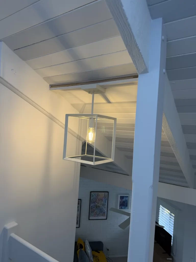 Lighting installation in Springwood: a pendant light on a raked ceiling, mounted on a custom angled timber base