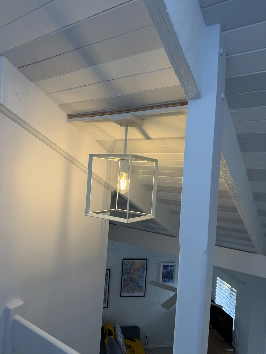 Lighting installation in Springwood: a pendant light on a raked ceiling, mounted on a custom angled timber base