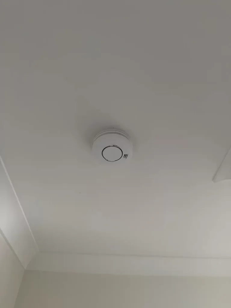 Photoelectric smoke alarm installation on a hallway ceiling in Carindale, Brisbane