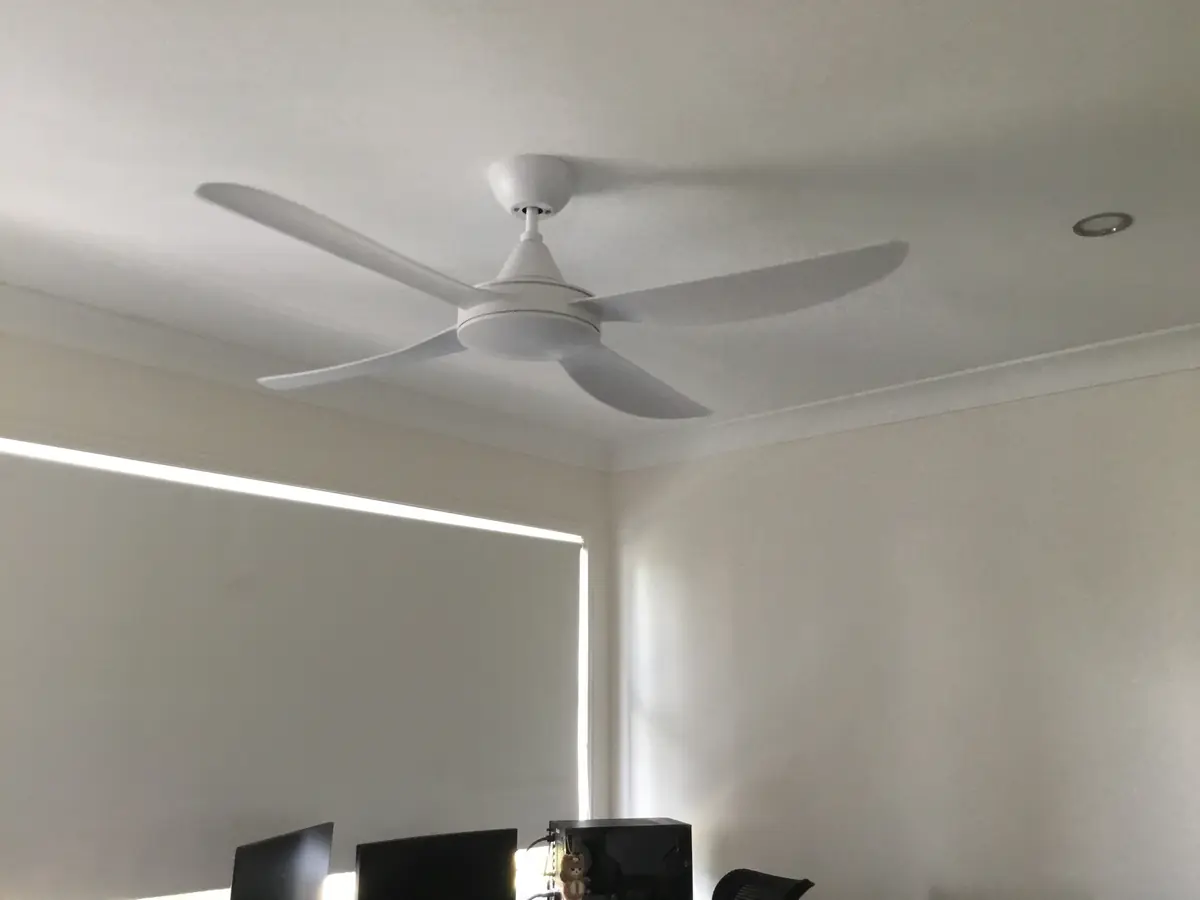 White wall-controlled ceiling fan installed in a living room by an electrician in Annerley